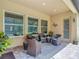 Covered outdoor patio featuring comfortable wicker furniture, a rug, and ample natural light at 1958 Marshberry Ct, Trinity, FL 34655