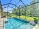 In-ground pool within a screened enclosure that looks out onto a green yard at 1958 Marshberry Ct, Trinity, FL 34655
