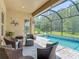 Relaxing screened-in pool area with outdoor seating, and lush landscaping at 1958 Marshberry Ct, Trinity, FL 34655