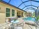 Outdoor screened-in pool area with a table, seating, and poolside lounging at 1958 Marshberry Ct, Trinity, FL 34655