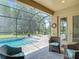 Relaxing screened-in pool area with spa, outdoor seating, and lush landscaping at 1958 Marshberry Ct, Trinity, FL 34655