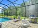 Inviting screened-in pool area with comfortable seating, BBQ grill, and lush backyard views at 1958 Marshberry Ct, Trinity, FL 34655