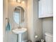 Stylish powder room featuring a pedestal sink, oval mirror, and modern fixtures at 1958 Marshberry Ct, Trinity, FL 34655