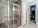 Modern shower with glass enclosure and tiled walls, adjacent to a walk in closet at 1958 Marshberry Ct, Trinity, FL 34655