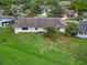Aerial view showcases the house, its backyard with beautiful tree coverage, and the surrounding neighborhood, highlighting its location at 2006 Hadrian Ct, Sun City Center, FL 33573
