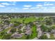 Extensive aerial view reveals a sprawling residential community with a lush golf course and tranquil lakes amidst a picturesque landscape at 2006 Hadrian Ct, Sun City Center, FL 33573