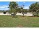 Spacious backyard with lush green lawn, mature trees, and exterior of the home, perfect for outdoor living and enjoyment at 2006 Hadrian Ct, Sun City Center, FL 33573