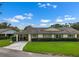 Well-kept single-story home with a carport and neat front lawn with manicured hedges at 2006 Hadrian Ct, Sun City Center, FL 33573