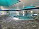 Inviting indoor pool area with ample seating, bright lighting, and well-kept tile flooring at 2006 Hadrian Ct, Sun City Center, FL 33573
