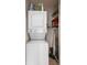 Efficient laundry area with stacked washer and dryer, and shelving for storage at 2006 Hadrian Ct, Sun City Center, FL 33573