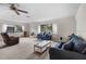 Cozy living room with plush sofas, neutral carpeting, and bright natural light from windows at 2006 Hadrian Ct, Sun City Center, FL 33573