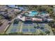 Scenic view of tennis courts and pool, with palm trees and nearby buildings at 2006 Hadrian Ct, Sun City Center, FL 33573