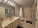 Neutral bathroom features a single sink vanity, tub and shower with handicap bars and non-slip rugs at 2221 Norwegian Dr # 15, Clearwater, FL 33763