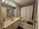 Neutral bathroom features a single sink vanity, tub and shower with handicap bars and non-slip rugs at 2221 Norwegian Dr # 15, Clearwater, FL 33763