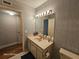 Bathroom featuring a vanity with a sink, decorative mirror, and wallpapered walls at 2221 Norwegian Dr # 15, Clearwater, FL 33763