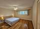 This bedroom has hardwood floors, ceiling fan, a large window, and modern lamps on each side of the bed at 2221 Norwegian Dr # 15, Clearwater, FL 33763