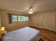 This bedroom has hardwood floors, a large window, a ceiling fan and an empty closet at 2221 Norwegian Dr # 15, Clearwater, FL 33763