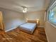 This bedroom has hardwood floors, ceiling fan, a large window, and modern lamps on each side of the bed at 2221 Norwegian Dr # 15, Clearwater, FL 33763