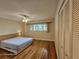 This bedroom has hardwood floors, a large window, a ceiling fan and an empty closet at 2221 Norwegian Dr # 15, Clearwater, FL 33763