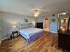 Cozy bedroom with hardwood flooring, large bed, ensuite bathroom, and a view of adjacent rooms at 2221 Norwegian Dr # 15, Clearwater, FL 33763