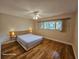 This bedroom has hardwood floors, ceiling fan, a large window, and modern lamps on each side of the bed at 2221 Norwegian Dr # 15, Clearwater, FL 33763