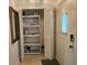 Hallway featuring storage shelves, decorative mirror and a door at 2221 Norwegian Dr # 15, Clearwater, FL 33763