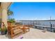 Waterfront patio area with comfortable wooden furniture and beautiful views of the water and dock at 2279 Mermaid Ne Pt, St Petersburg, FL 33703