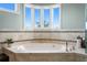 Spacious bathtub sits beneath bay window in luxurious bathroom with tile accents at 2279 Mermaid Ne Pt, St Petersburg, FL 33703