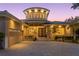 Elegant two-story home with a circular tower and manicured landscaping at dusk at 2279 Mermaid Ne Pt, St Petersburg, FL 33703