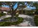 Elegant home with a circular driveway, mature trees, and lush, well-maintained landscaping at 2279 Mermaid Ne Pt, St Petersburg, FL 33703