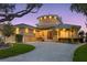Elegant home with circular tower, paver driveway, and lush landscaping at dusk at 2279 Mermaid Ne Pt, St Petersburg, FL 33703