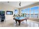 Bright game room featuring a pool table, pinball machine, and picturesque water views from large windows at 2279 Mermaid Ne Pt, St Petersburg, FL 33703