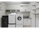 Functional laundry room with modern washer and dryer, storage cabinets, and ample shelving at 2279 Mermaid Ne Pt, St Petersburg, FL 33703