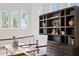Charming loft with wood floors, natural light from three windows, and a decorative shelving unit and desk at 2279 Mermaid Ne Pt, St Petersburg, FL 33703