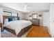 This spacious bedroom features hardwood floors, a ceiling fan, and a large window that provides ample natural light at 412 Manor Blvd, Palm Harbor, FL 34683