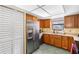 Bright kitchen featuring stainless steel refrigerator, wood cabinets, and ample storage at 412 Manor Blvd, Palm Harbor, FL 34683