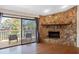 Cozy living room with stone fireplace, hardwood floors, and sliding doors leading to a private balcony at 412 Manor Blvd, Palm Harbor, FL 34683