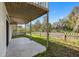 The back patio features a covered area, a fence, and green grass at 412 Manor Blvd, Palm Harbor, FL 34683