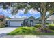 Charming single-story home with a well-manicured lawn, mature landscaping, and attached two-car garage at 4315 Whittner Dr, Land O Lakes, FL 34639