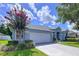 This single-story home features a well-maintained lawn, beautiful landscaping, and an attached two-car garage at 4315 Whittner Dr, Land O Lakes, FL 34639