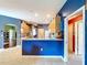 Stylish kitchen with blue accent wall, tile floors, and natural wood cabinets at 4315 Whittner Dr, Land O Lakes, FL 34639