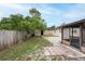 View of the home's backyard featuring a shed, screened in patio, and a wood privacy fence at 4323 S Lois Ave, Tampa, FL 33611