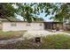 The home's backyard featuring the back of the home and a screened in patio and room for a fire pit at 4323 S Lois Ave, Tampa, FL 33611