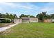 Exterior view of the home, featuring a well-manicured front lawn and neutral color scheme at 4323 S Lois Ave, Tampa, FL 33611