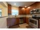 Efficient kitchen layout featuring stainless steel appliances and wooden cabinetry at 4323 S Lois Ave, Tampa, FL 33611