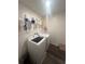 Functional laundry room with a front-loading washer and dryer, and shelves for storage at 4743 Deer Track St, Tampa, FL 33610