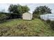 Wide angle of overgrown backyard with shed and white picket fence at 4920 S 82Nd St, Tampa, FL 33619