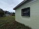 Corner of light green home with window bars and overgrown yard at 4920 S 82Nd St, Tampa, FL 33619