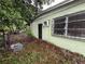 Side view of exterior showcasing cinder block construction and window with iron security bars at 4920 S 82Nd St, Tampa, FL 33619