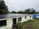 Angle shot of the exterior shows the roof, windows, front door and surrounding greenery at 4920 S 82Nd St, Tampa, FL 33619
